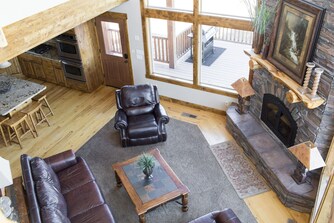 Living room with stone fireplace and view to the deck